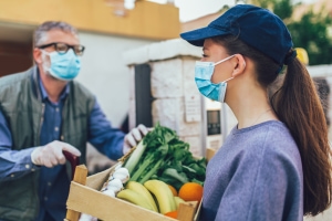 woman providing man with fresh produce in a box