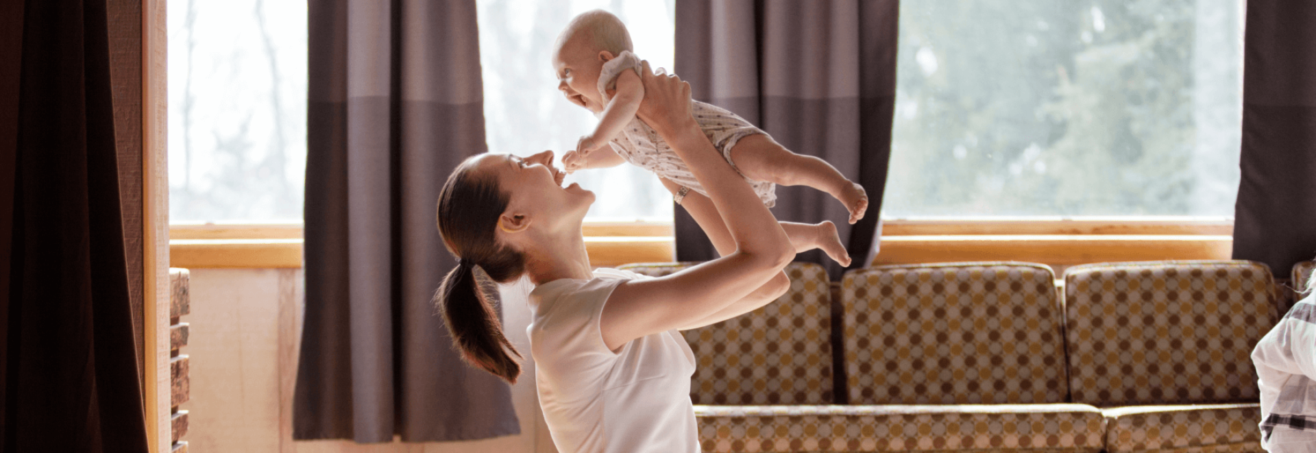 a woman holding a baby up in the air