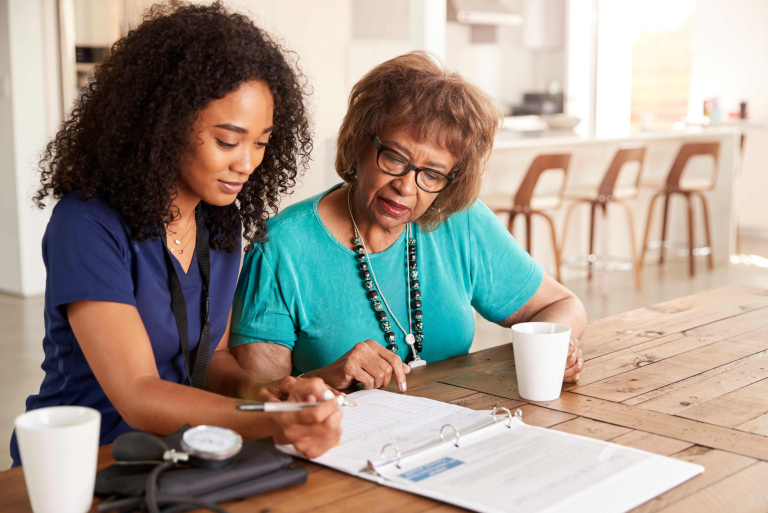 a woman and a young woman looking at a document