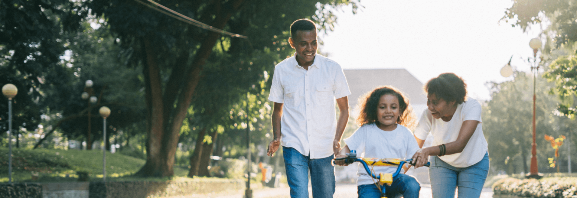 a man and girl walking with a bicycle