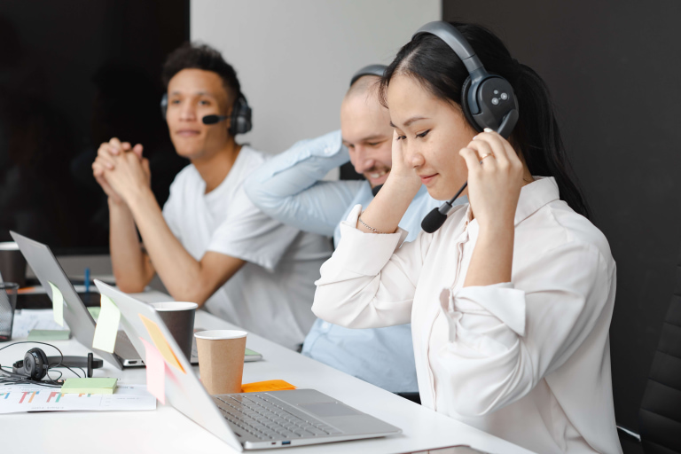 a group of people sitting at a table with headsets